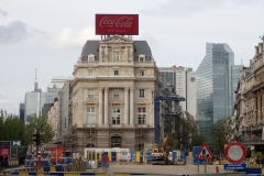 Kontrast: ALtbau mit Coca-Cola-Werbung, dahinter Bürogebäude aus Glas