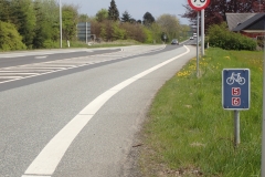 offizielle Radrouten an vielbefahrener Straße auf schmalen Seitestreifen