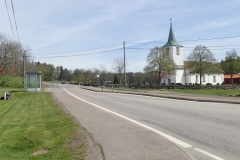 Dorfkirche; dabei fällt auf,dass die Bushaltestelle so eng gebaut ist, dass keiner den Bus überholen kann