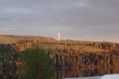 weißes, riesiges Kreuz auf Anhöhe gegenüber dem Campingplatz